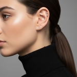 Profile of a model wearing the Marquise Double Diamond Drop Stud in her helix piercing, paired with two diamond studs.