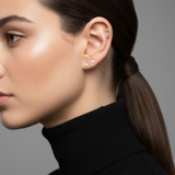 Profile of a model wearing the Marquise Double Diamond Drop Stud in her helix piercing, paired with two diamond studs.