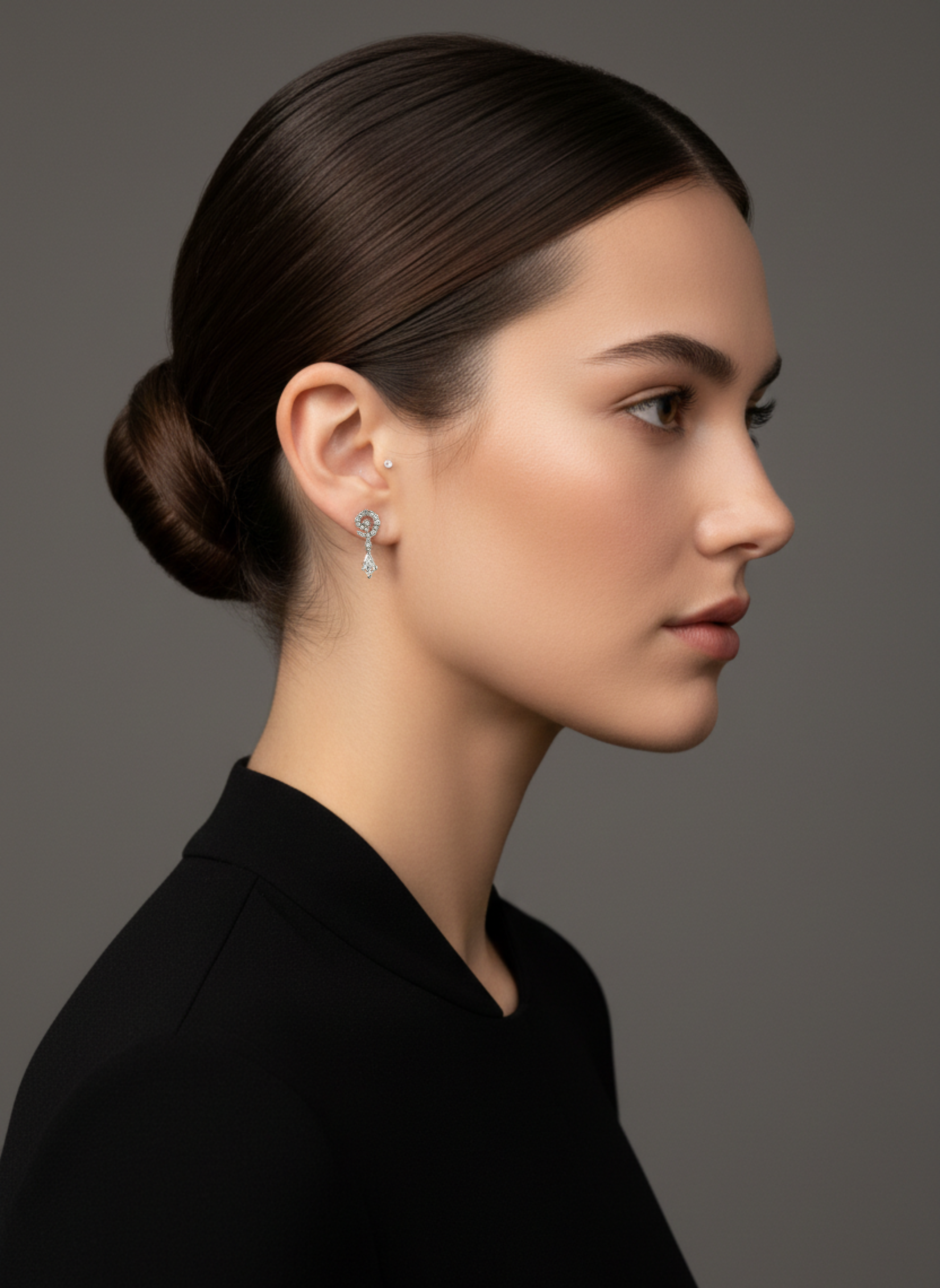 Model in profile wearing the Lark & Berry Celestial Swirl Diamond Stud earring with a dangling drop-shaped diamond.