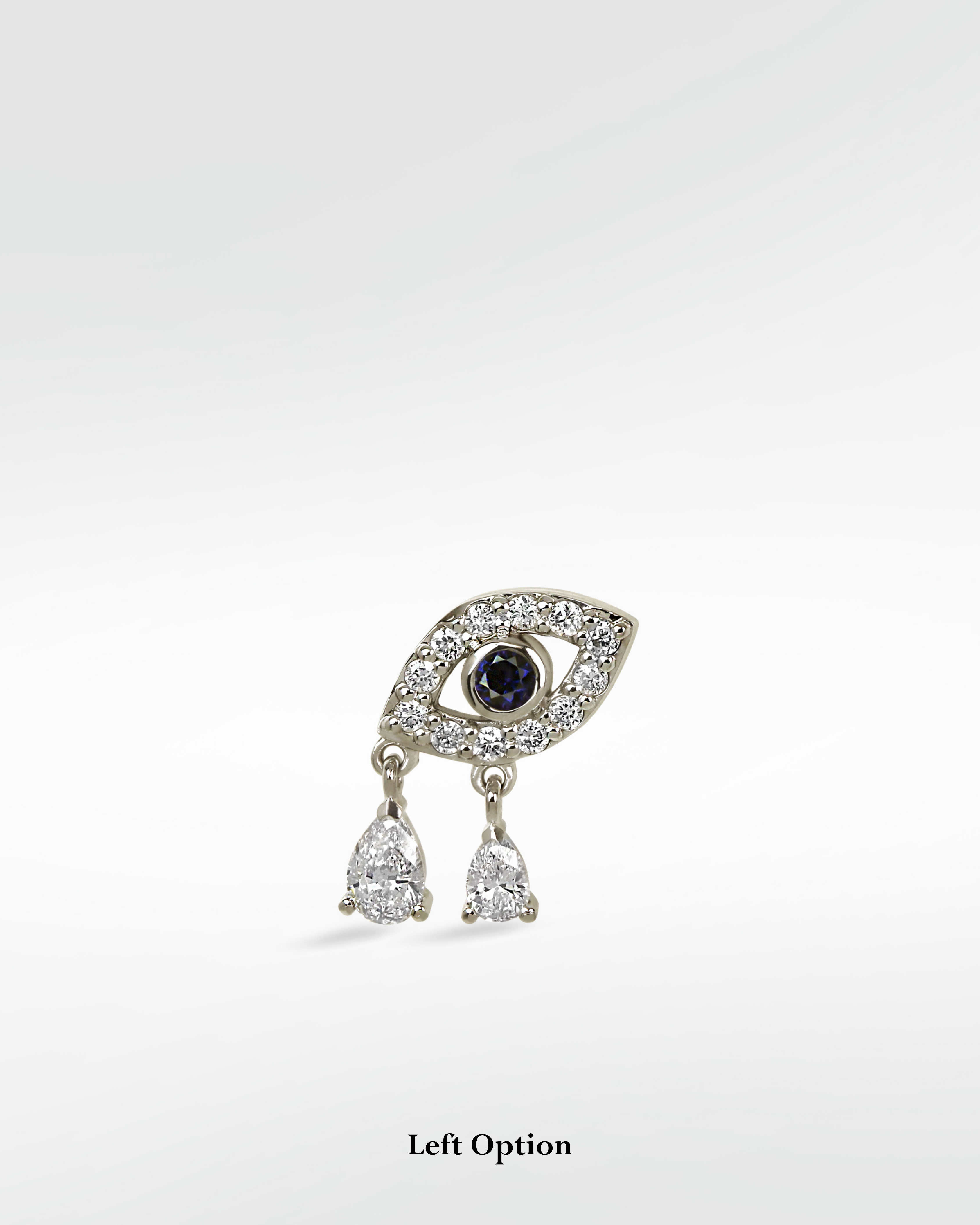 White gold evil eye earring with a sapphire pupil, diamond outline, and two dangling pear-shaped diamond drops.