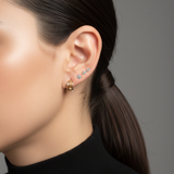 A close-up on a model's ear styled with gold diamond hoops and the Lark & Berry Double Diamond Kite Stud.