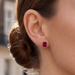 A close-up of a model's ear, wearing an emerald-cut ruby stud earring from the Lark & Berry London Bridge collection.