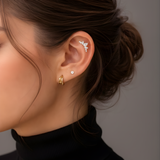 Model's ear styled with Lark & Berry's Crown Crawler diamond cartilage earring, a stud, and a gold hoop.