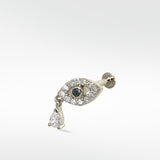 14k white gold evil eye stud earring with a blue sapphire, pavé diamonds, and a dangling pear-shaped diamond.