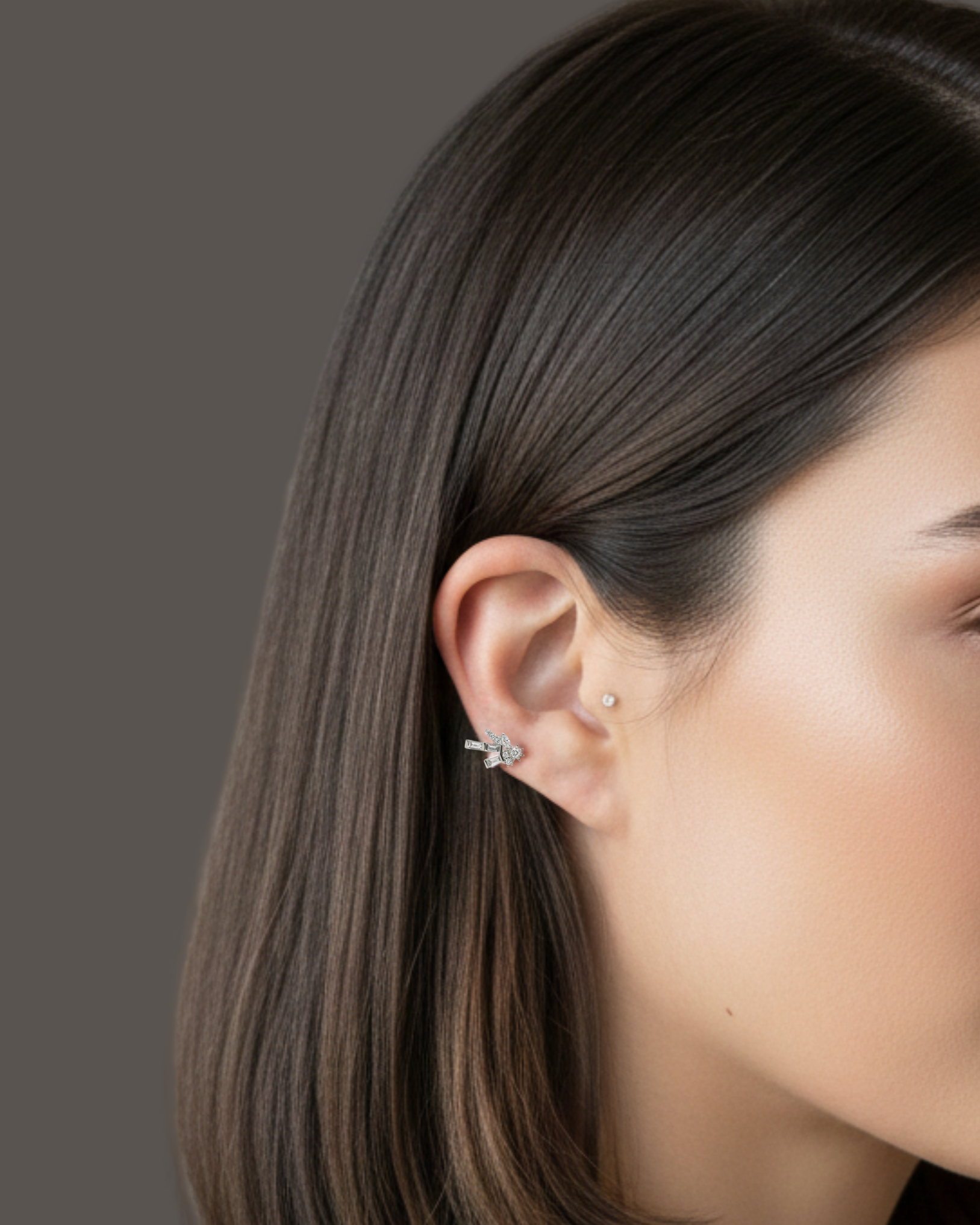 Close-up of a model wearing the Firework Diamond Stud earring, featuring a cluster of baguette and round diamonds on the earlobe.