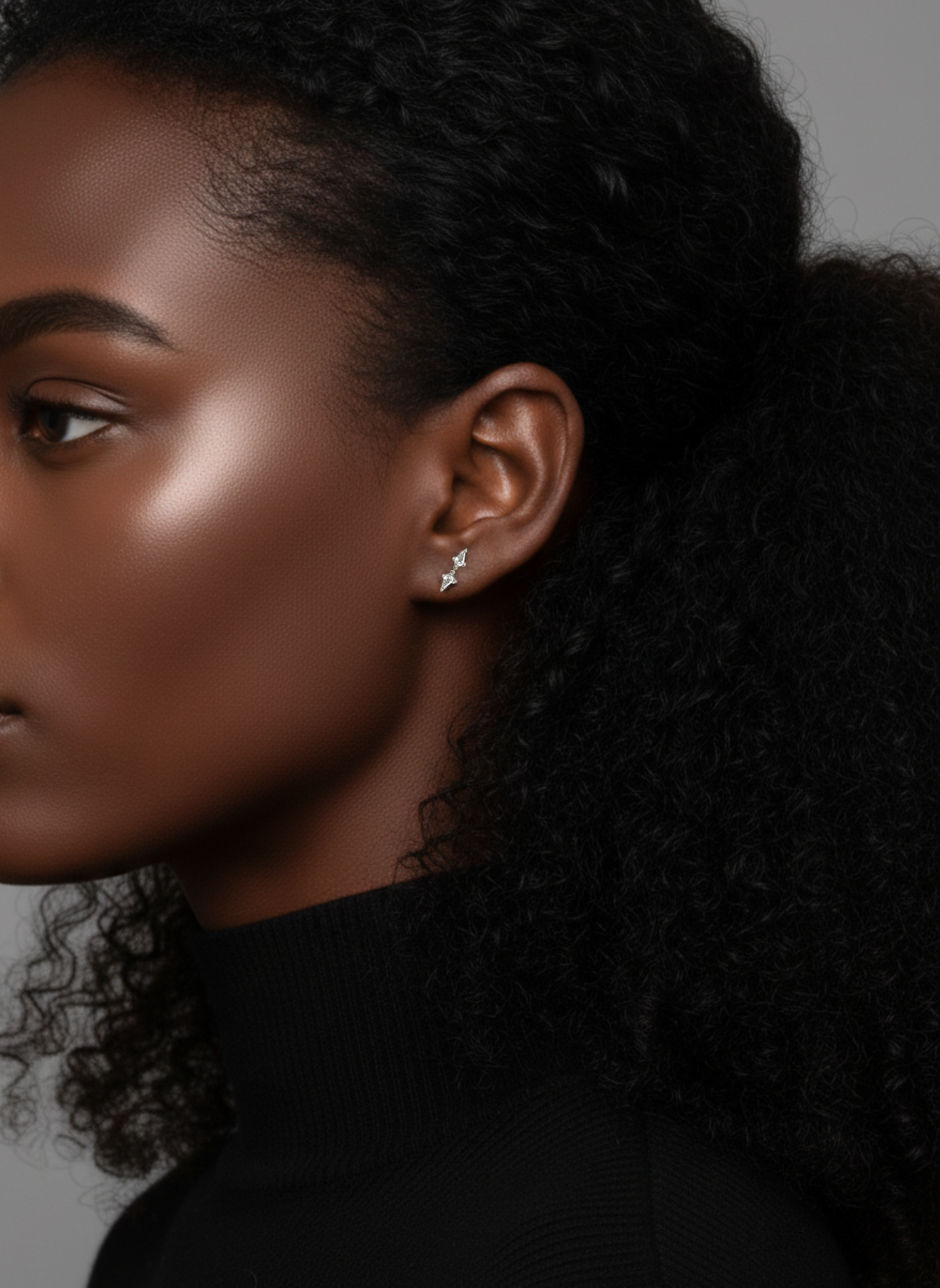 Close-up of a model wearing the Lark & Berry Double Diamond Kite Stud earring, highlighting its placement on the ear.