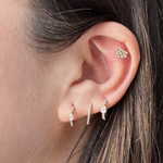 Model's curated ear featuring the gold and diamond Modernist Marquise Pave Hoop, styled with other pavé earrings.