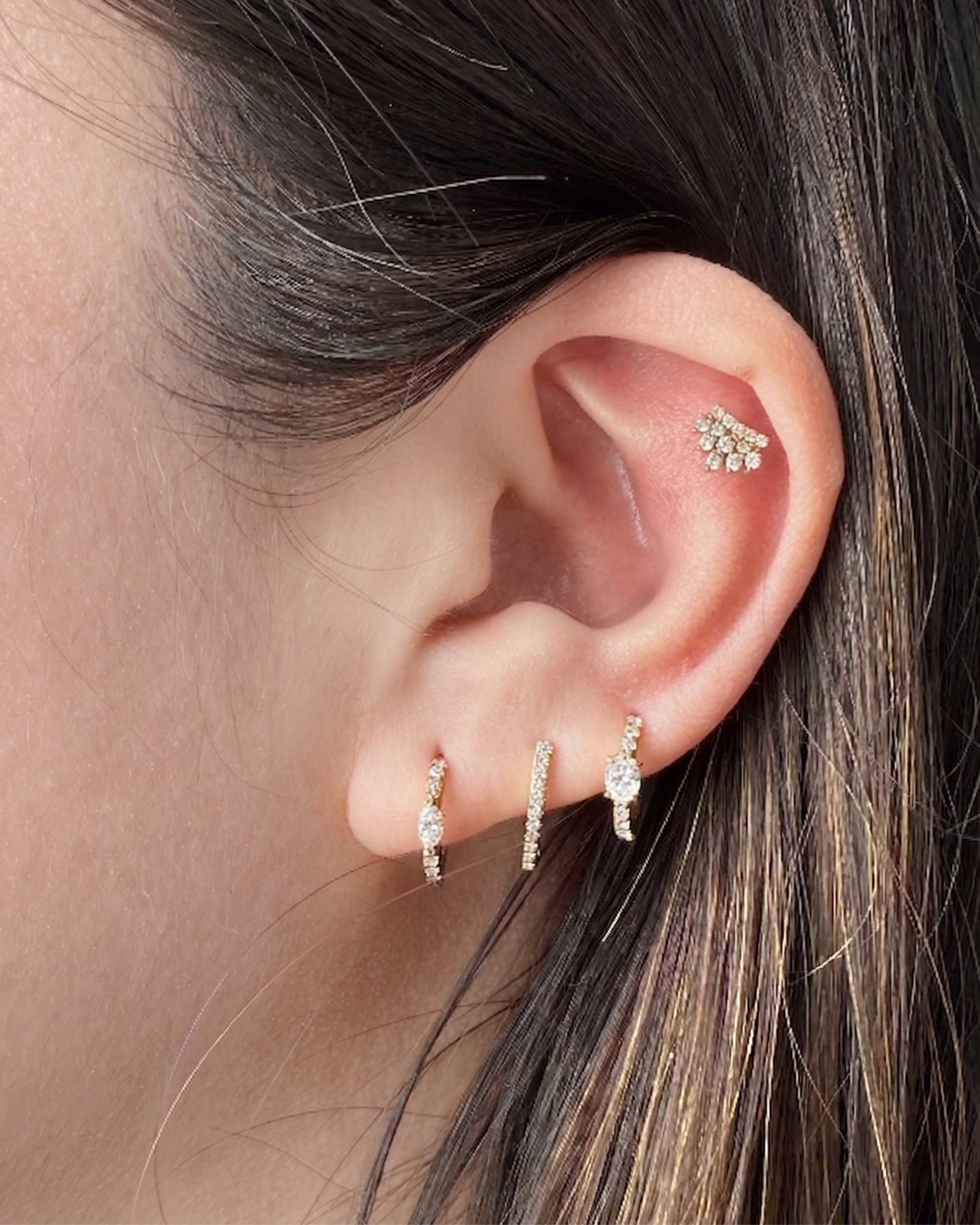 Model's curated ear featuring the gold and diamond Modernist Marquise Pave Hoop, styled with other pavé earrings.